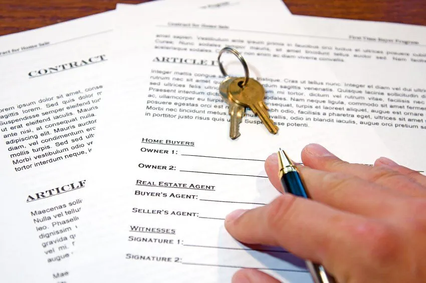 Close-up of a house contract being signed during a real estate transaction