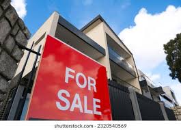 A 'For Sale' sign from a real estate agent in front of a modern Australian home