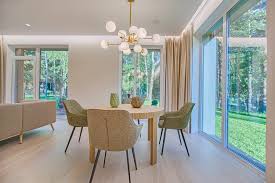 A bright, staged living room with neutral walls and furniture pulled away from the walls, demonstrating a key staging secret for real estate for sale.