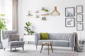 A beautifully staged living room with a "Sold" sign being placed on the front lawn.