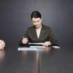 A couple sitting at a table with a mediator, house keys between them