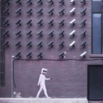 A picture of a masked man walking around cameras