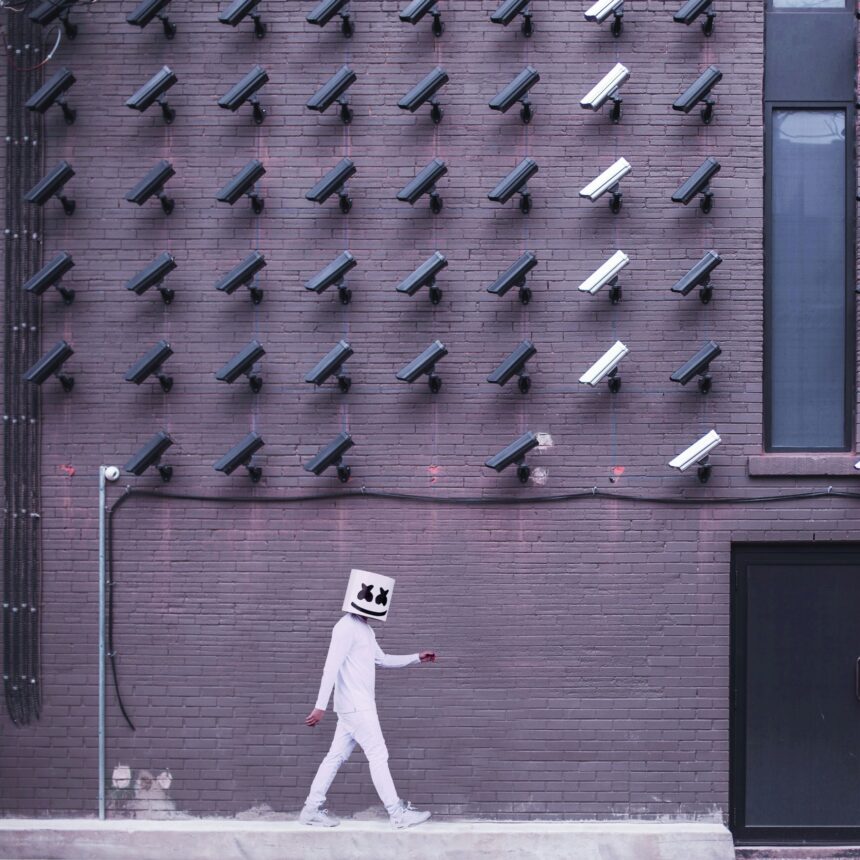 A picture of a masked man walking around cameras